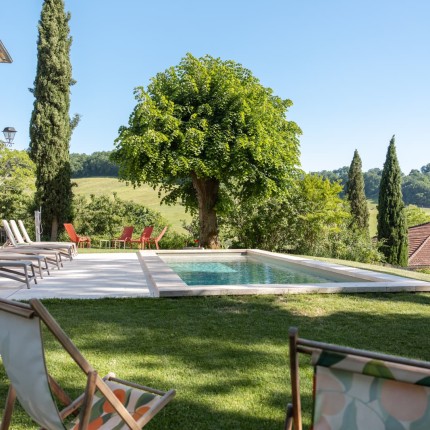 Piscine chauffée et transats du gîte au soleil