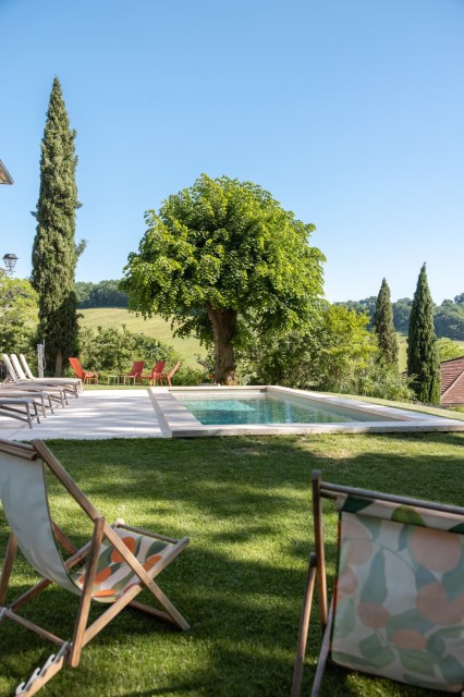 Piscine chauffée et transats au soleil, chaises longues dans le jardin du gîte près d'Agen