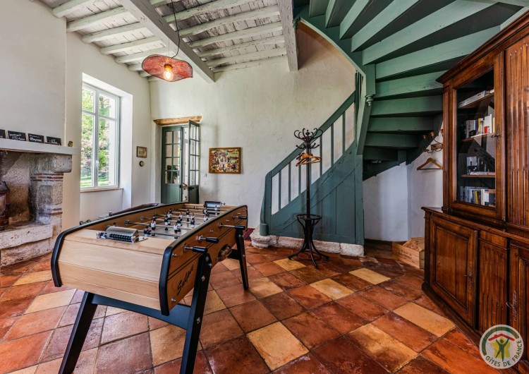 Salon anglais avec baby-foot, bibliothèque et escalier, soirées en famille au gîte dans le Sud-Ouest