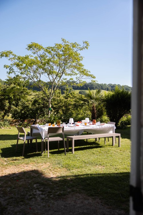 Table dressée dans le jardin sous les arbres, repas entre amis au gîte en Lot-et-Garonne