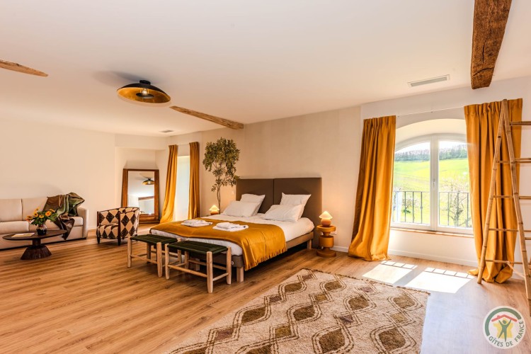 Chambre lumineuse aux tons naturels avec parquet et vue sur la campagne, stage bien-être au gîte près d'Agen