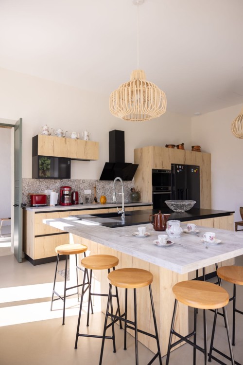 Cuisine équipée avec îlot central et tabourets, repas de famille au gîte de groupe près d'Agen