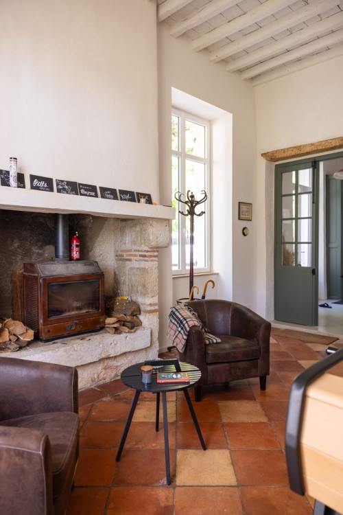 Salon avec poêle à bois et fauteuils club pour les temps de détente du séminaire, gîte près d'Agen